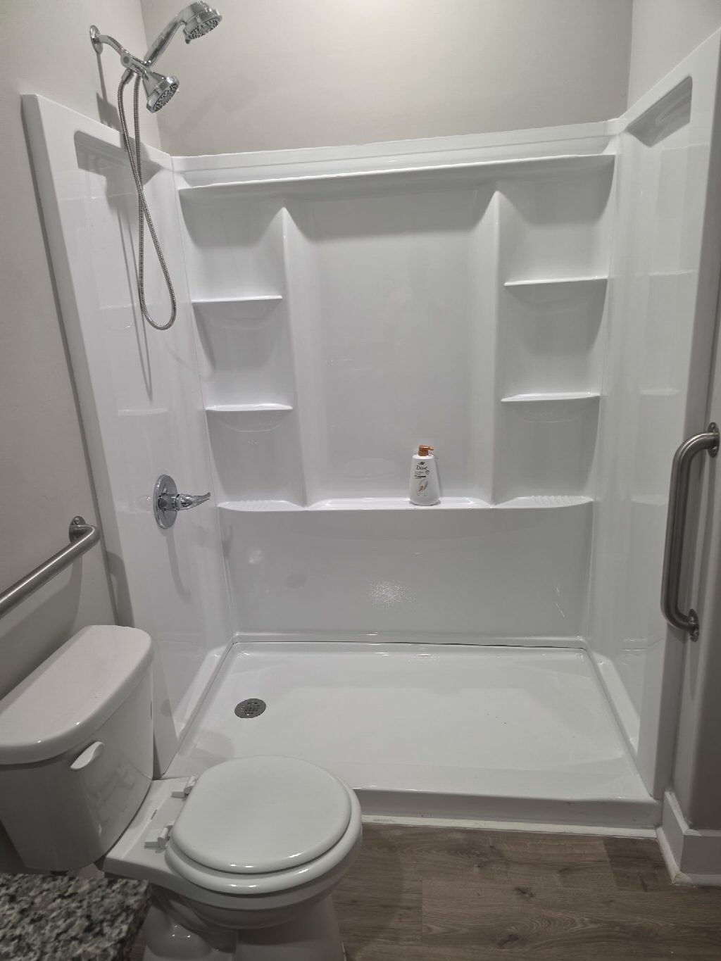 Step-in shower with grab bars and a fold-down seat