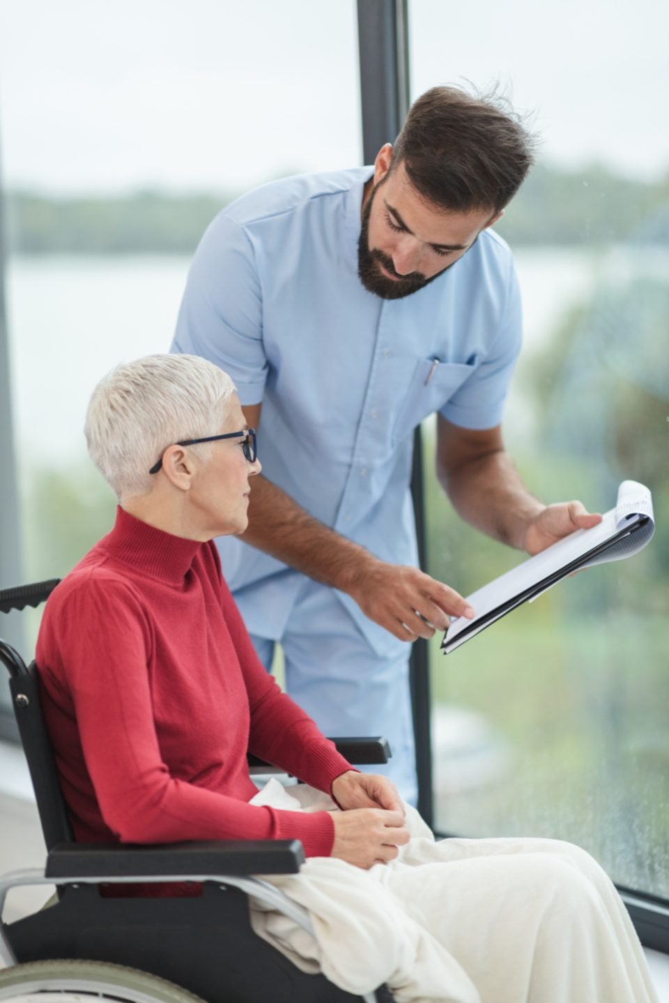 A caregiver going through a written care plan with a resident