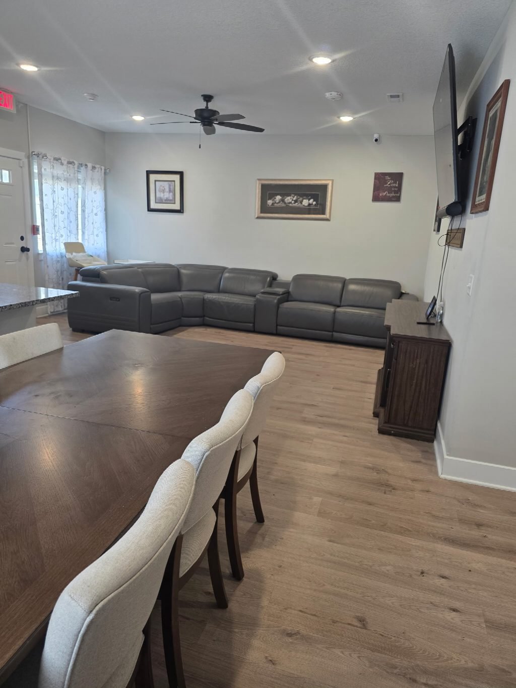 The living room seen from the dining table, with sofas and a large television