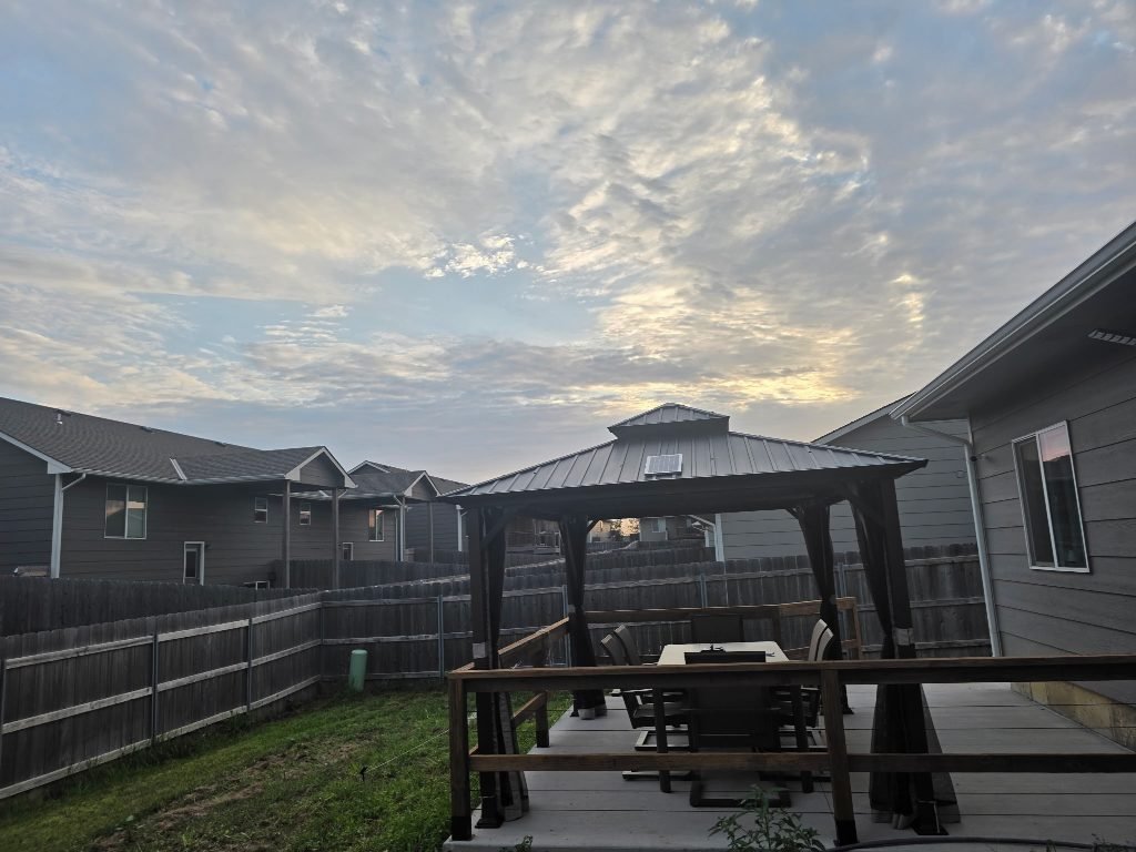 The fully fenced garden under an evening sky